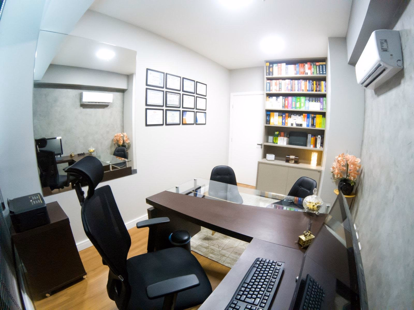 Sala de atendimento da Da Mata com mesa e biblioteca jurídica